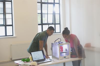 Два дизайнери, дивлячись на 3D-принтер