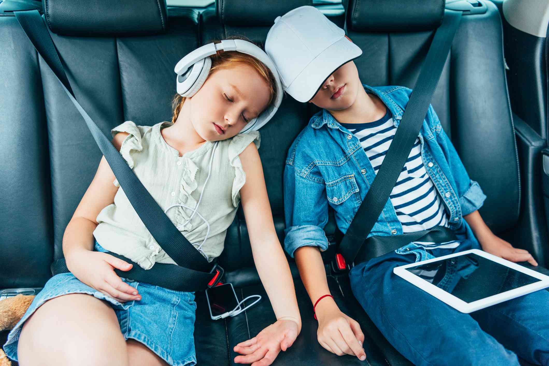 Двоє дітей спали в машині, тримаючи в руках електронні пристрої, які можна було використовувати для шкільних робіт. 
