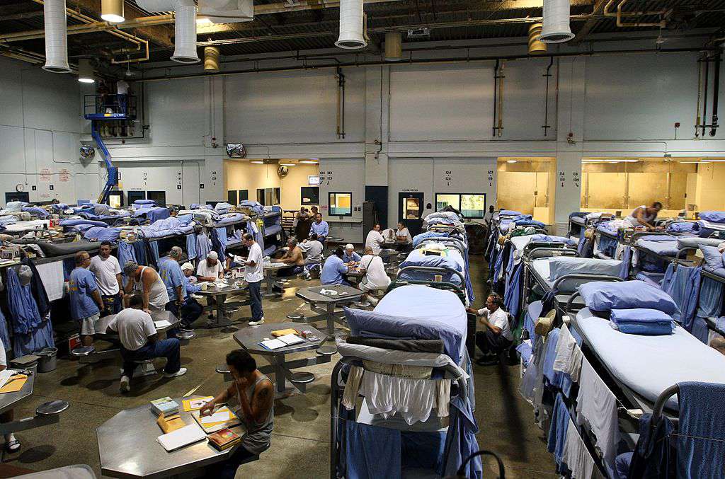 Ув'язнені в'язниці штату Мюл-Крік взаємодіють у спортзалі, який був модифікований для розміщення в'язнів