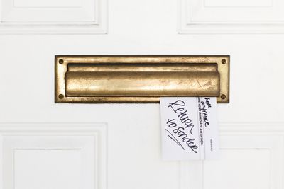 An envelope stuck in a mail slot with Return to Sender written on it