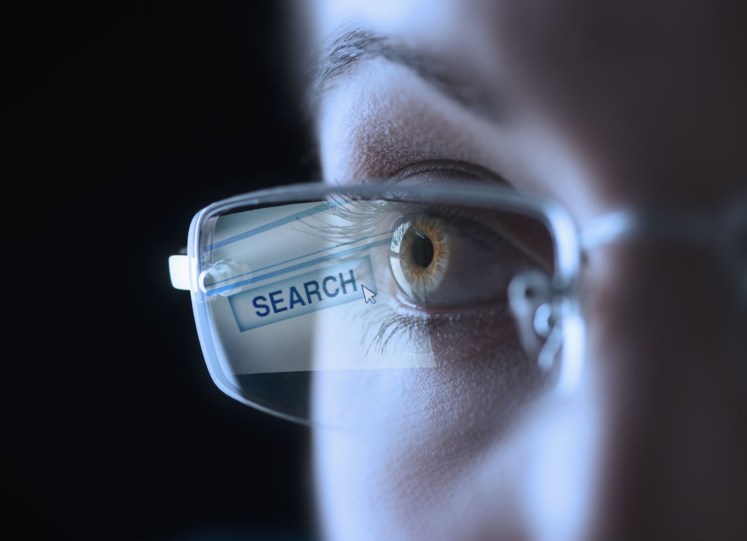 Коса-кап людського ока в окулярах із кнопкою пошуку, що відбивається на об’єктиві.